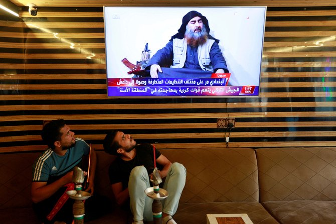Iraqi youth watch the news of Daesh leader Abu Bakr al-Baghdadi death, in Najaf, Iraq, on October 27, 2019. (Reuters)
