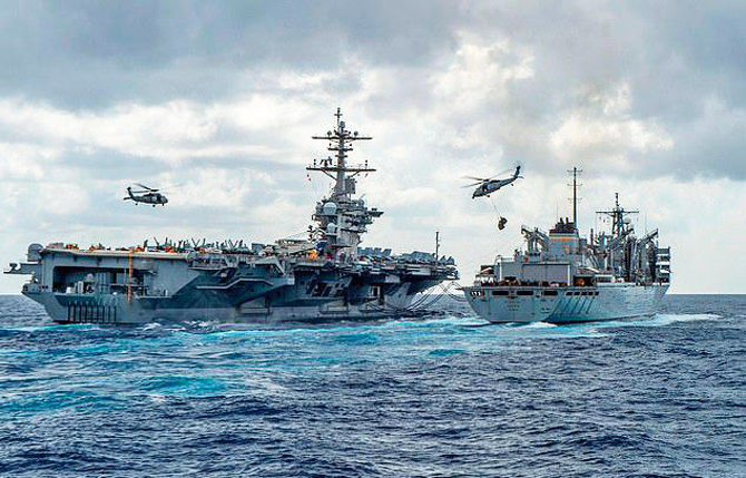 The US Navy's aircraft carrier USS Abraham Lincoln (CVN 72) while conducting a replenishment-at-sea with the fast combat support ship USNS Arctic (T-AOE 9), while MH-60S Sea Hawk helicopters assigned to the 