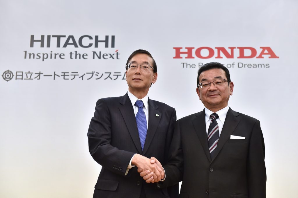 Honda Motor President, CEO and representative director Takahiro Hachigo (R) shakes hands with Hitachi Automotive Systems President and CEO Hideki Seki (L) following their joint press conference in Tokyo on February 7, 2017. (File phot/AFP)