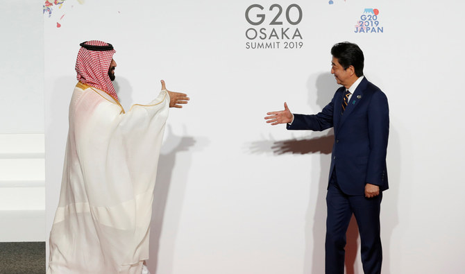 Crown Prince Mohammed bin Salman is welcomed by Japanese Prime Minister Shinzo Abe at the G20 Summit in Osaka on Friday. (Reuters)