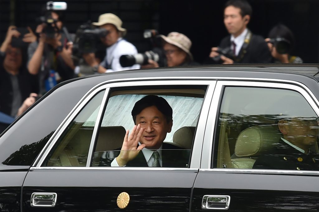 Japan’s new Emperor Naruhito (C) waves to well-wishers as he arrives at the Imperial Palace in Tokyo on May 1, 2019. (AFP)
