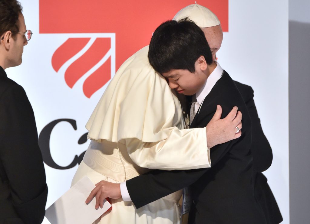 Pope Francis (C) and a student, one of three-disaster victims to make speech as part of their testimony, hug each other during a meeting with the victims of triple disaster in Tokyo on November 25, 2019. (AFP)