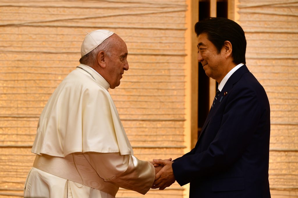 Pope Francis (L) shakes hands with Japan's Prime Minister Shinzo Abe (R) during a meeting with the diplomatic community at the prime minister's official residence in Tokyo on November 25, 2019. (AFP)
