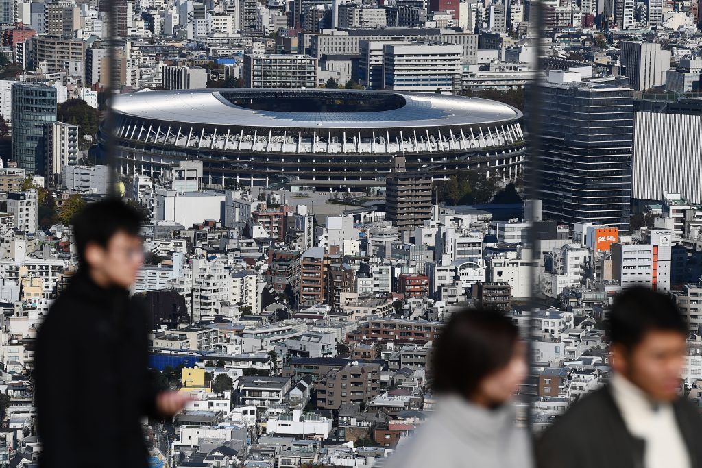 People at a viewing area look out at the new 1.4 billion USD main venue (C) for the 2020 Tokyo Olympic Games after being officially completed in Tokyo on November 30, 2019. The five-story stadium, designed by renowned Japanese architect Kengo Kuma, will seat 60,000 fans. (AFP)
