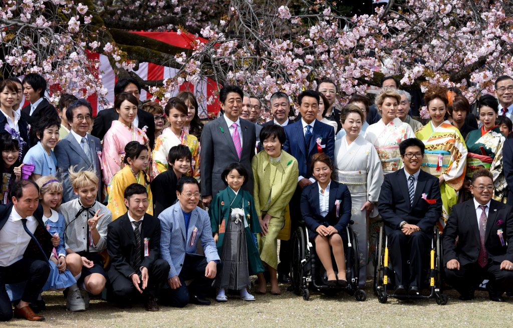 Japan's Prime Minister Shinzo Abe (centre L) and his wife Akie (centre R) posing with entertainers and athletes during the cherry blossom viewing party hosted by the prime minister in Tokyo. (AFP file)