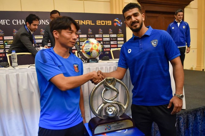 Urawa’s midfielder Kazuki Nagasawa, left, and Al Hilal’s goalkeeper Abdullah Al-Mayouf with the AFC Champions League trophy in the Saudi capital Riyadh. (AFP)