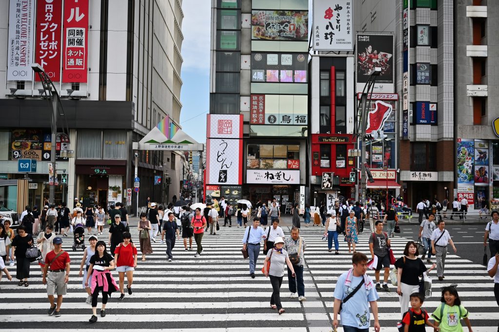 Pedestrians cross a street in Tokyo’s Ueno district on August 8, 2019. (AFP)