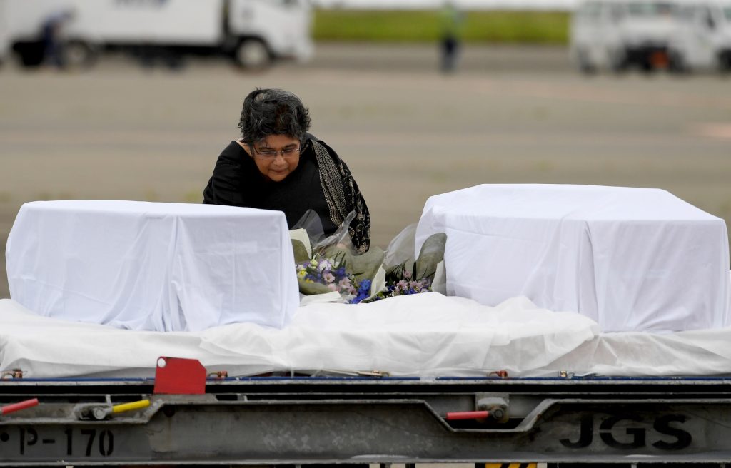 Bangladesh’s Ambassador to Japan Rabab Fatima places a bouquet of flowers among the coffins of Japanese victims upon their arrival at Tokyo International Airport at Haneda on July 5, 2016 from Dhaka following a siege at a Bangladesh café. (AFP)