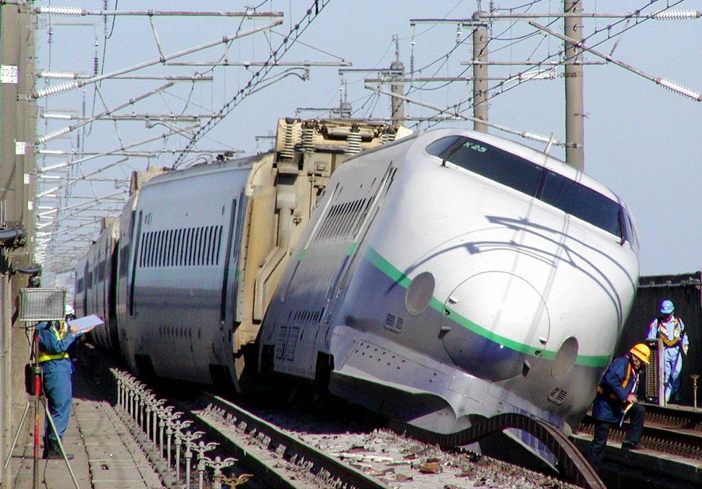 Investigators and employees of railway company inspect the Shinkansen bullet train derailed by a 23 October strong earthquake in Nagaoka, Niigata Prefecture, 24 October 2004. (JIJI PRESS/AFP)