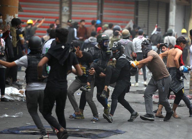 Iraqi demonstrators carry wounded comrade during clashes with security forces on al-Rashid street in the capital Baghdad, amid ongoing anti-government protests, on November 27, 2019. (FILE/AFP)