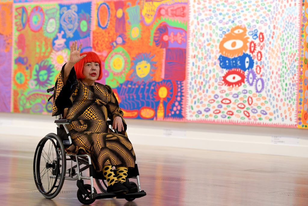 Yayoi Kusama waves at a photo session during a press preview of her exhibition titled “My Eternal Soul” at the National Art Center in Tokyo on February 21, 2017. (AFP)
