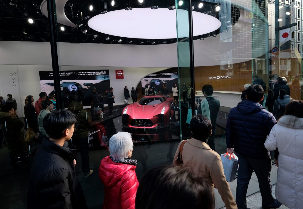 Pedestrians walk in front of a Nissan car showroom in Tokyo’s shopping district Ginza on December 31, 2018. (AFP)