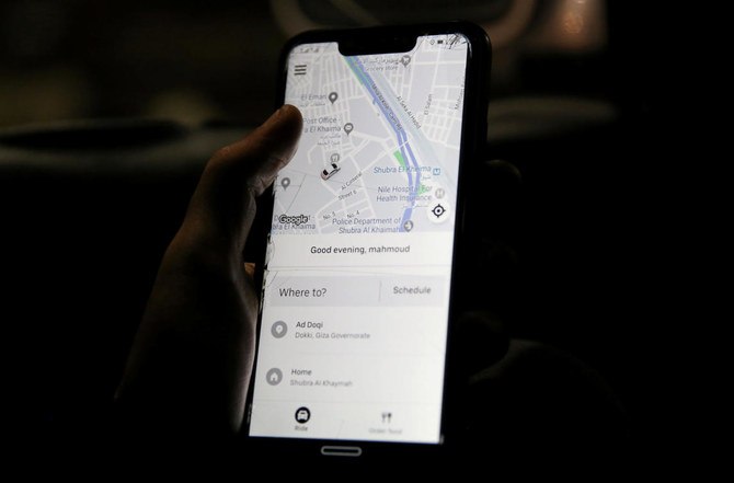 A man uses Uber application on his mobile phone in Cairo, November 6, 2019. (Reuters)