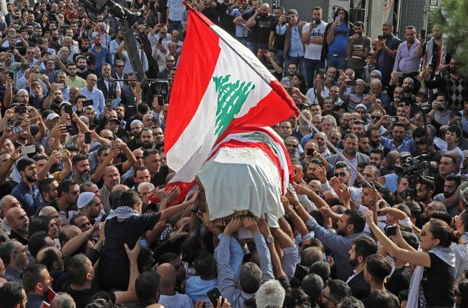 The coffin of slain Lebanese protester Alaa Abou Fakhr, draped in a national flag, is carried by mourners through the streets of his hometown of Chouaifet, southeast of Beirut, during his funeral procession on November 14, 2019. (AFP)