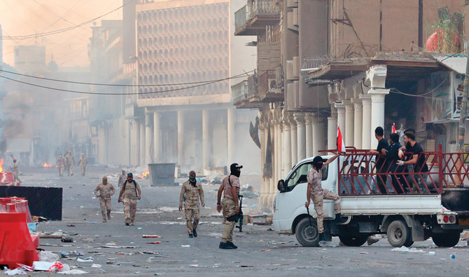 Iraqi security forces arrest volunteers while distributing food for protesters during ongoing anti-government protests in Baghdad on Thursday. (AP)