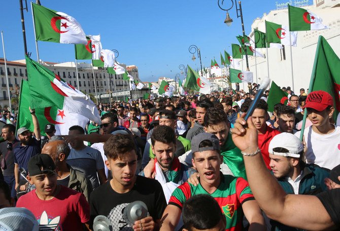 Demonstrators shout slogans and carry national flags during a protest against the country's ruling elite, on the anniversary of the 1954 revolution against French colonial rule, in Algiers. (Reuters)