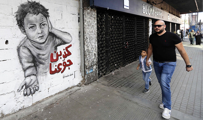 A man walks past a graffiti drawn on the wall of a building at the Al-Nour Square in the northern port city of Tripoli. (AFP)