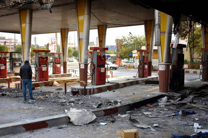 An Iranian man checks a scorched gas station that was set ablaze by protesters during a demonstration against a rise in gasoline prices in Eslamshahr, near the Iranian capital of Tehran, on Sunday. (AFP)