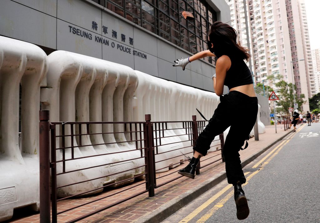 A protester hurls a brick at a police station in Hong Kong’s Tseung Kwan O district. (Reuters)