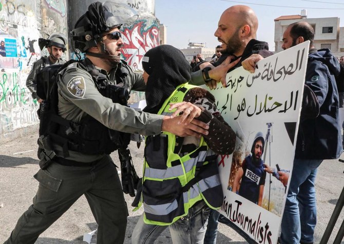 Palestinian journalists stand in solidarity with Palestinian cameraman Mu'ath Amarneh who days before was injured in his eye by a rubber bullet while covering clashes between Palestinian protesters and Israeli security forces in a West Bank demonstration. (AFP)