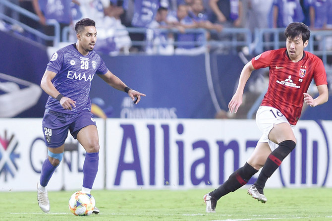Al-Hilal’s Salem Al-Dawsari, left, plays the ball past Urawa Reds’ Takuya Aoki during Saturday’s match at King Fahd stadium in Riyadh. (AP)
