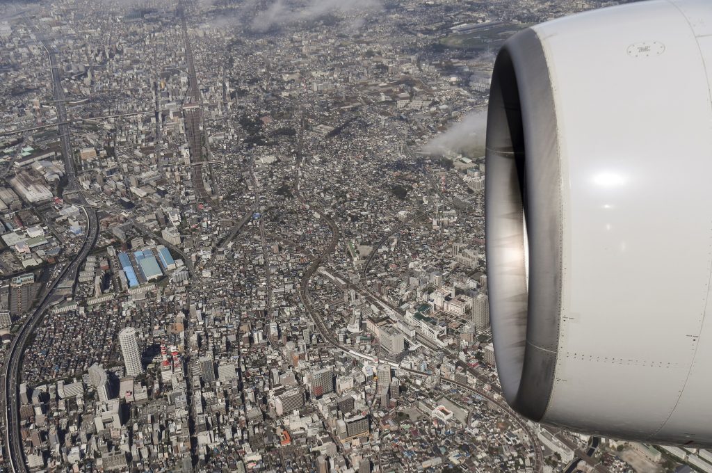 An aerial view shows the sprawling metropolis of Tokyo lying below the engine of an ANA Boeing 777 as it prepares to land at Tokyo’s Haneda Airport on September 23, 2019. (AFP)