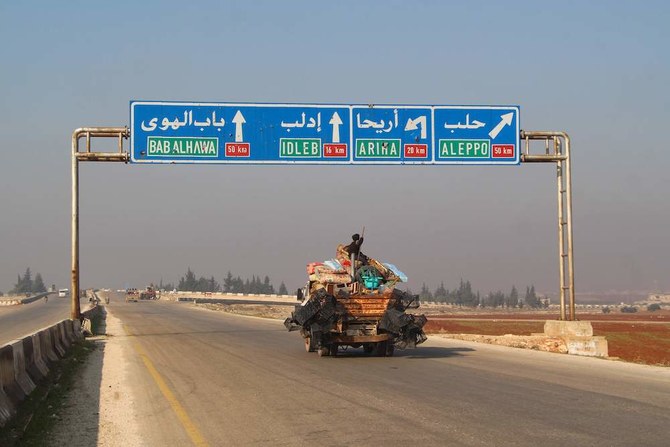 A Syrian boy sits atop personal effects in the back of a pick-up truck fleeing bombardment in the town of Saraqib, in the northwestern Idlib province, on Dec. 21, 2019, as tens of thousands of civilians are fleeing bombardment. (AFP)