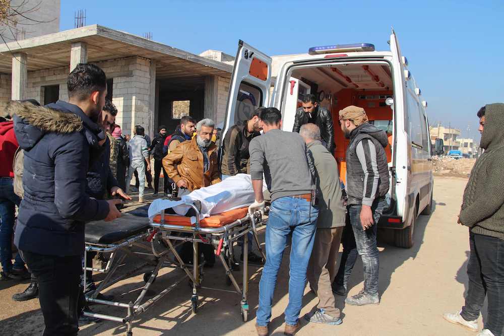 Syrian men transfer a victim to an ambulance following a reported Syrian air strike in the town of Saraqib, in the northwestern Idlib province on Dec. 21, 2019. (AFP)