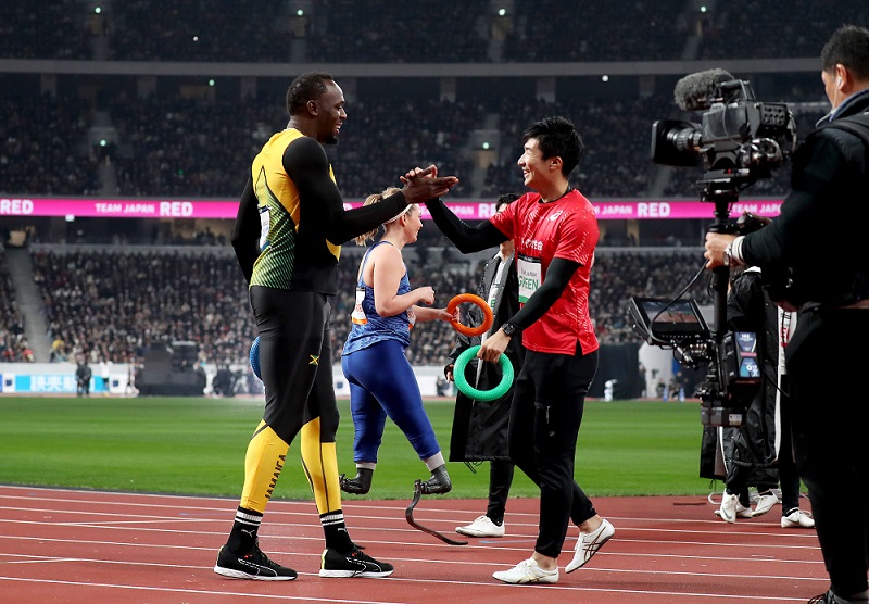 In this handout picture released by the JSC (Japan Sport Council), Usain Bolt (left) shakes hands with Japanese sprinter Yoshihide Kiryu following a relay competition at the opening event for the new National Stadium, venue for the upcoming Tokyo 2020 Olympic Games, in Tokyo on December 21, 2019. (AFP)