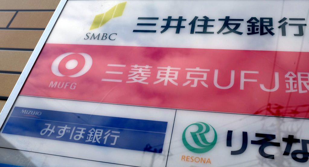 Logos of Japan's banks (from top to bottom L), Sumitomo Mitsui Financial Group, Mitsubishi UFJ Financial Group (MUFG), and Mizuho Financial Group are displayed on a signboard in Tokyo on November 13, 2015. (File photo/AFP)