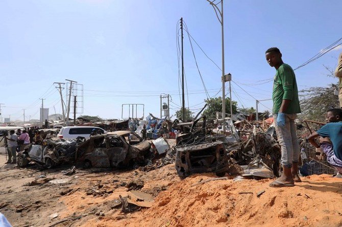 A resident stands at the scene of a car bomb explosion at a checkpoint in Mogadishu. (Reuters)