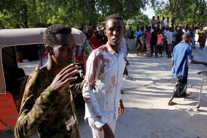 A resident wounded in the car bomb attack is helped by a friend at check point in Mogadishu, Somalia on Saturday, Dec. 28, 2019. (AP)