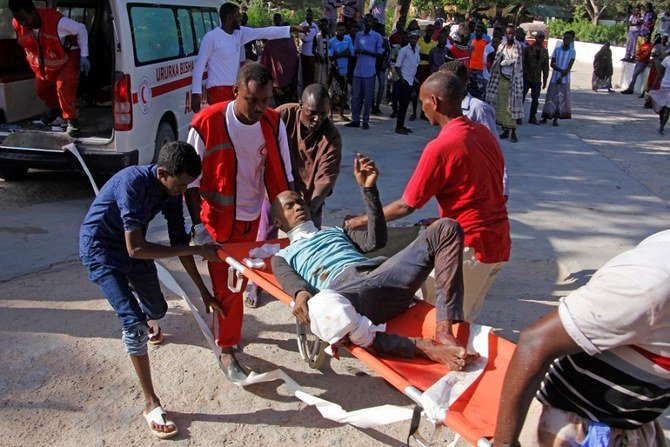 A resident wounded in the car bomb attack is helped by a friend at check point in Mogadishu, Somalia on Saturday, Dec, 28, 2019. (AP) Medical personnel evacuate a resident wounded in the car bomb attack in Mogadishu, Somalia on Saturday, Dec. 28, 2019. (AP)