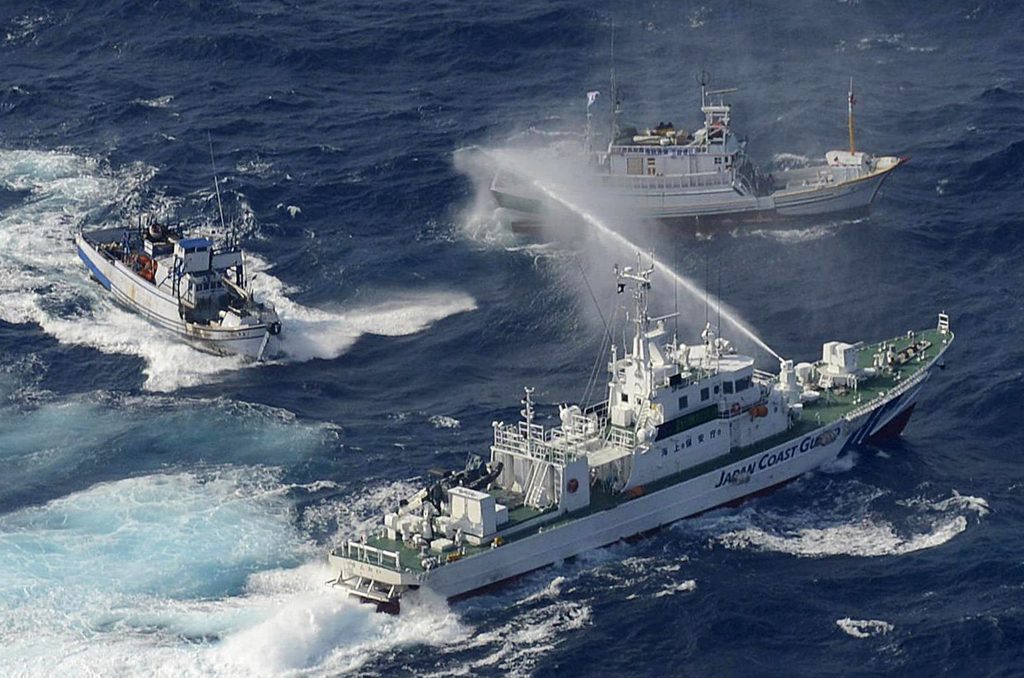A Japan Coast Guard vessel (lower) sprays water against Taiwanese fishing boats, in the East China Sea near the Senkaku islands as known in Japanese or Diaoyu Islands in Chinese on September 25, 2012. (File photo/AFP)