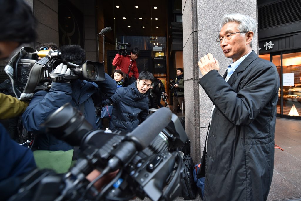 The Japanese lawyer for Carlos Ghosn, Junichiro Hironaka (R), leaves after a press briefing outside his office in Tokyo on December 31, 2019. (AFP)