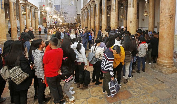 Christian tourists visit the Church of the Nativity in the biblical West Bank city of Bethlehem on December 21, 2019. (AFP)