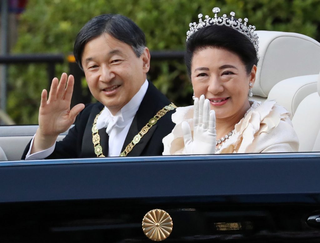 Japan’s Emperor Naruhito (L) and Empress Masako (R) wave during a royal parade in Tokyo on November 10, 2019. (JIJI PRESS / AFP)