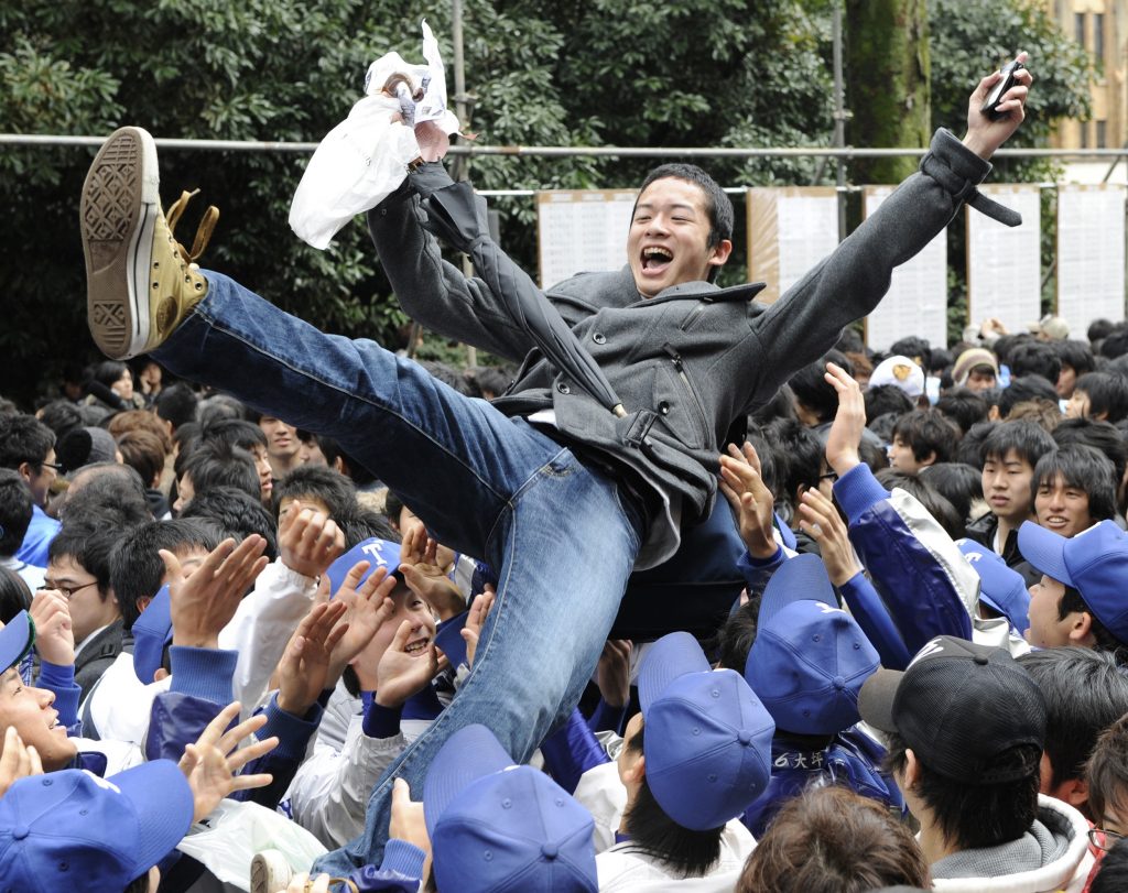 A student is tossed into the air in a celebration after passing the entrance examination for a prestigious Tokyo University in Tokyo on March 10, 2010. (File photo/AFP)