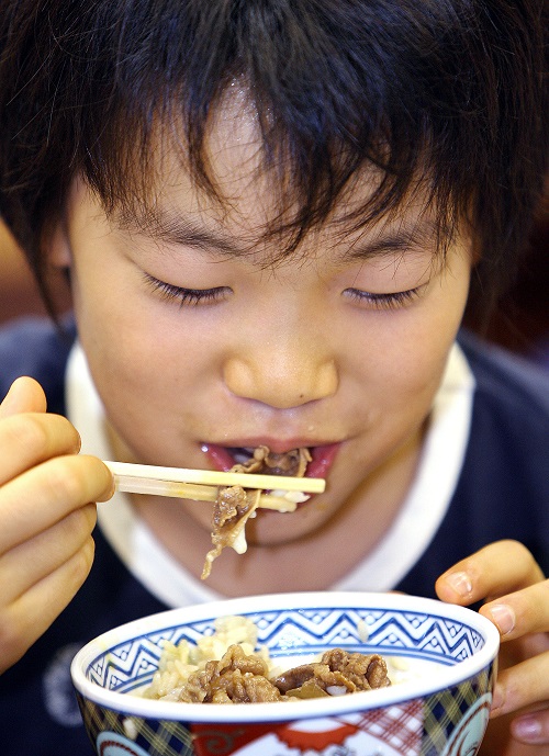 A young Japanese boy enjoys a bowl of 