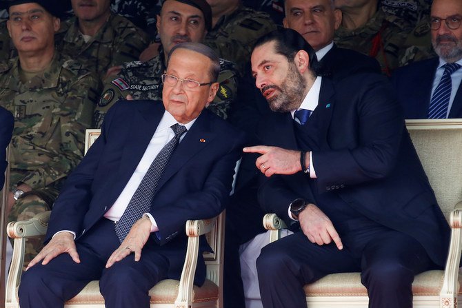 Lebanon’s Saad Al-Hariri chats with Lebanon’s President Michel Aoun during a military parade to mark the 76th anniversary of Lebanon’s independence at the Ministry of Defense in Yarze, Lebanon. (File/Reuters)