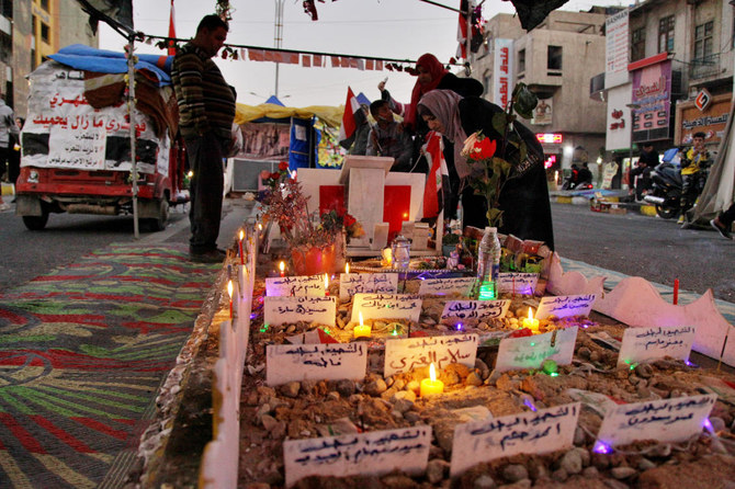 People light candles for protesters who have been killed in anti-government demonstrations in Tahrir Square, Baghdad. (AP)
