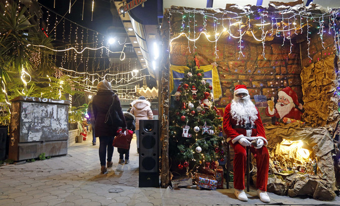A Syrian man dressed as Santa Claus waits for visitors in Al-Qassaa neighbourhood in Damascus. (AFP)