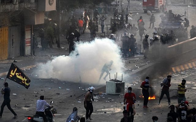 Iraqi police fire teargas at protesters during a demonstration against state corruption, failing public services and unemployment in Tayaran square, Baghdad. (AFP)