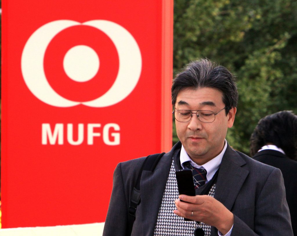 A pedestrian passes before a branch of Mitsubishi UFJ bank in Tokyo on November 14, 2012. (AFP)