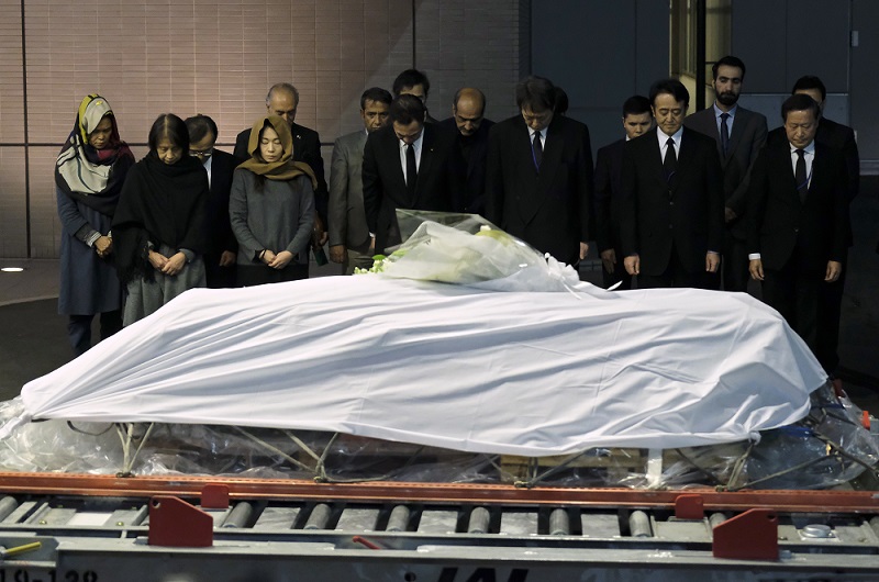 Government officials and relatives of late Japanese physician Tetsu Nakamura offer silent prayers in front of Nakamura's coffin upon arrival from Afghanistan at Narita Airport in Chiba prefecture on Tuesday. (AFP)