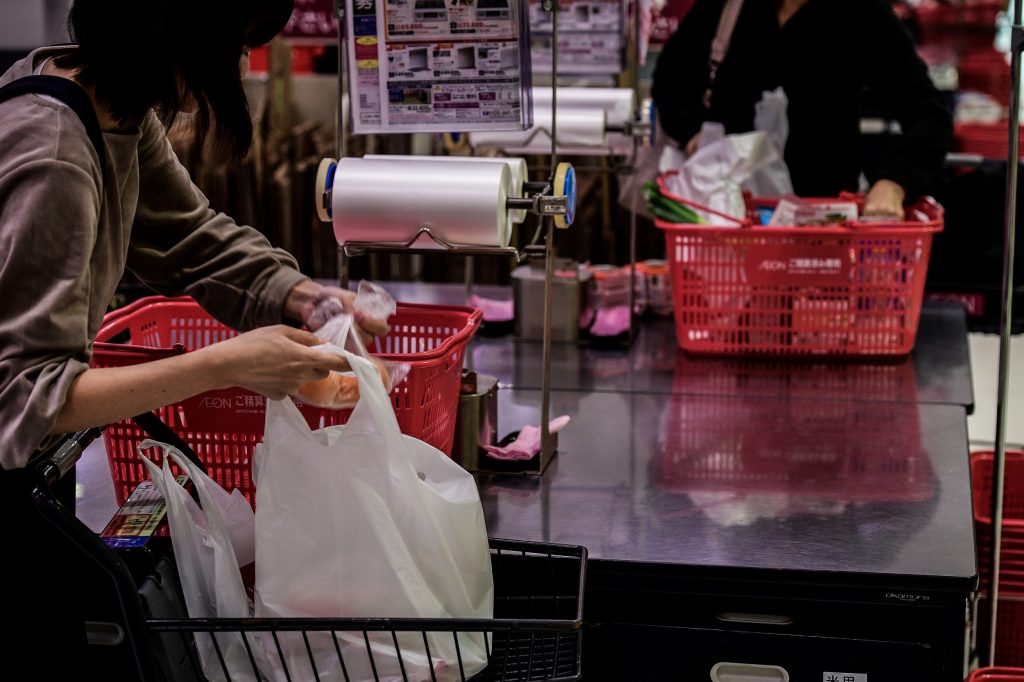 A woman packs her shopping into a plastic bag in a supermarket in Chiba on November 7, 2018. (AFP)
