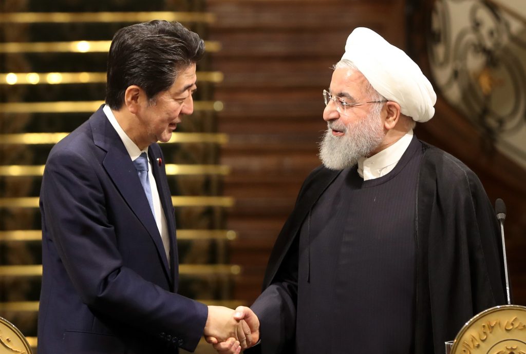 Iranian President Hassan Rouhani (R) shakes hands with Japanese Prime Minister Shinzo Abe in Tehran on June 12, 2019. (AFP) 