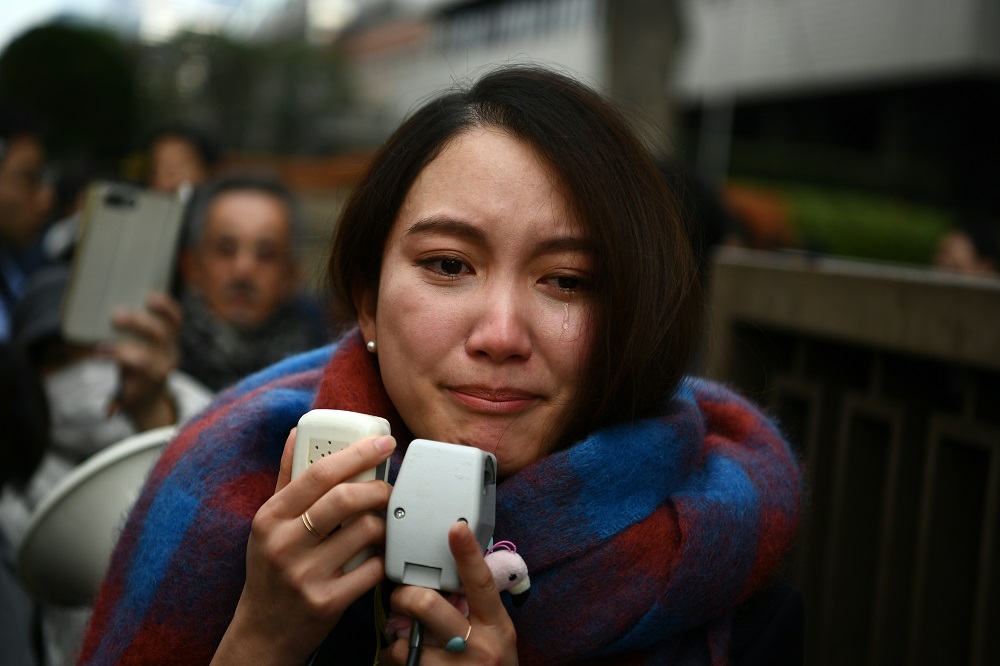 Japanese journalist Shiori Ito sheds a tear as she speaks to reporters outside the Tokyo district court on December 18, 2019 after hearing the ruling on a damages lawsuit by her, accusing a former TV reporter of rape. (AFP)