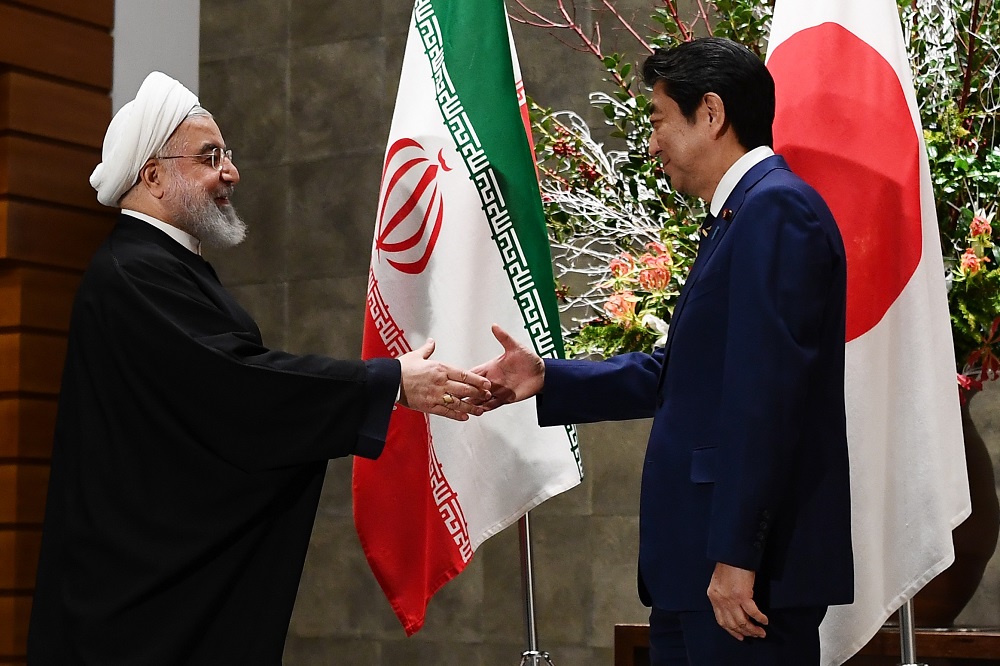 Iranian President Hassan Rouhani (left) shakes hands with Japanese Prime Minister Shinzo Abe before a meeting at the prime minister's office in Tokyo on December 20, 2019. (AFP)