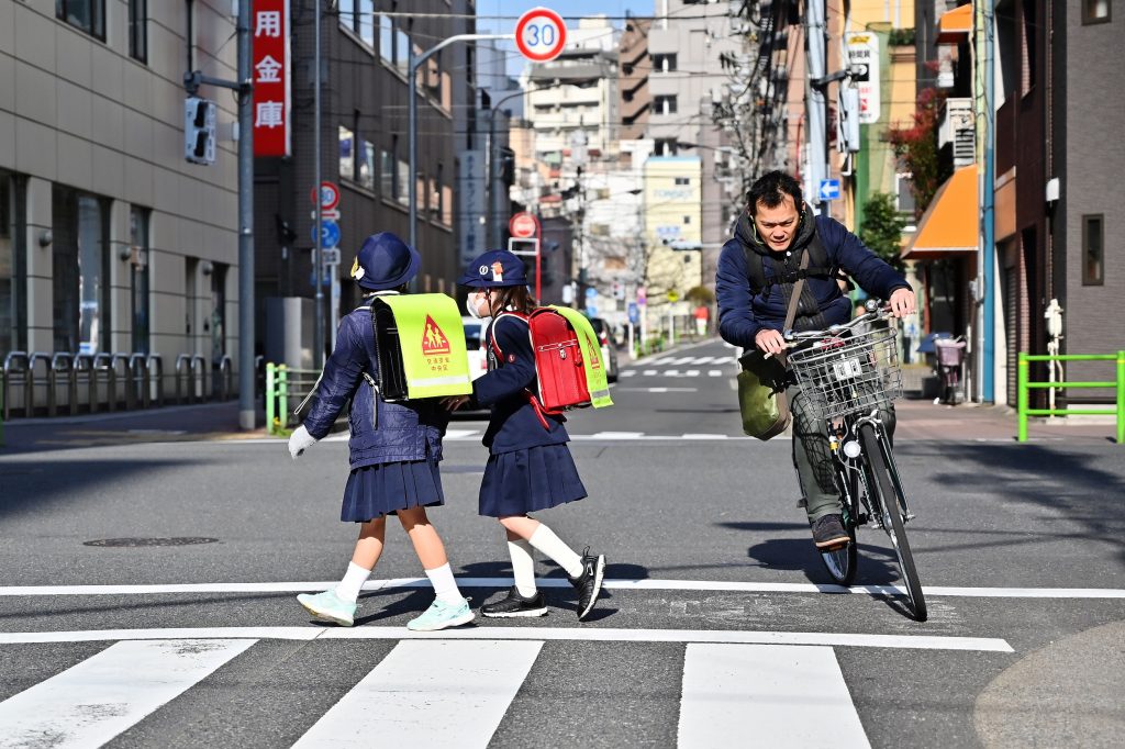 Girls go to school in Tsukiji district, Tokyo on March 19, 2019. (AFP)